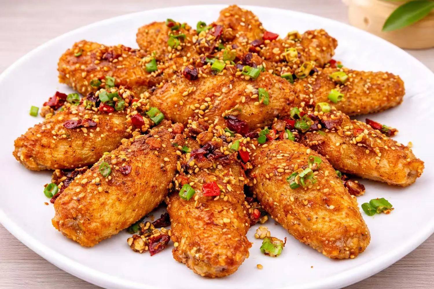 Crispy fried chicken wings topped with sesame seeds, dried chilies, and scallions